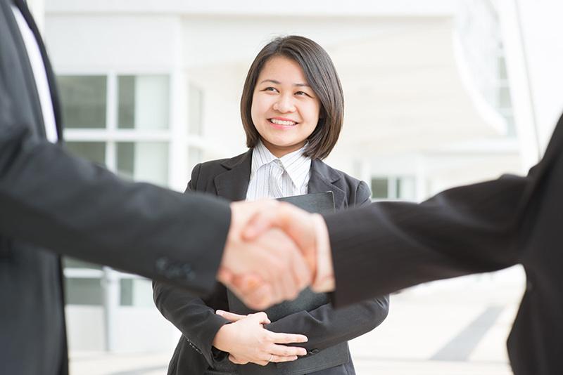 business deal, asian businessmen handshaking. focus on assistant or secretary.